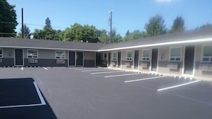 A building with a parking lot and multiple rooms. - North Idaho Inn (Coeur d'Alene)