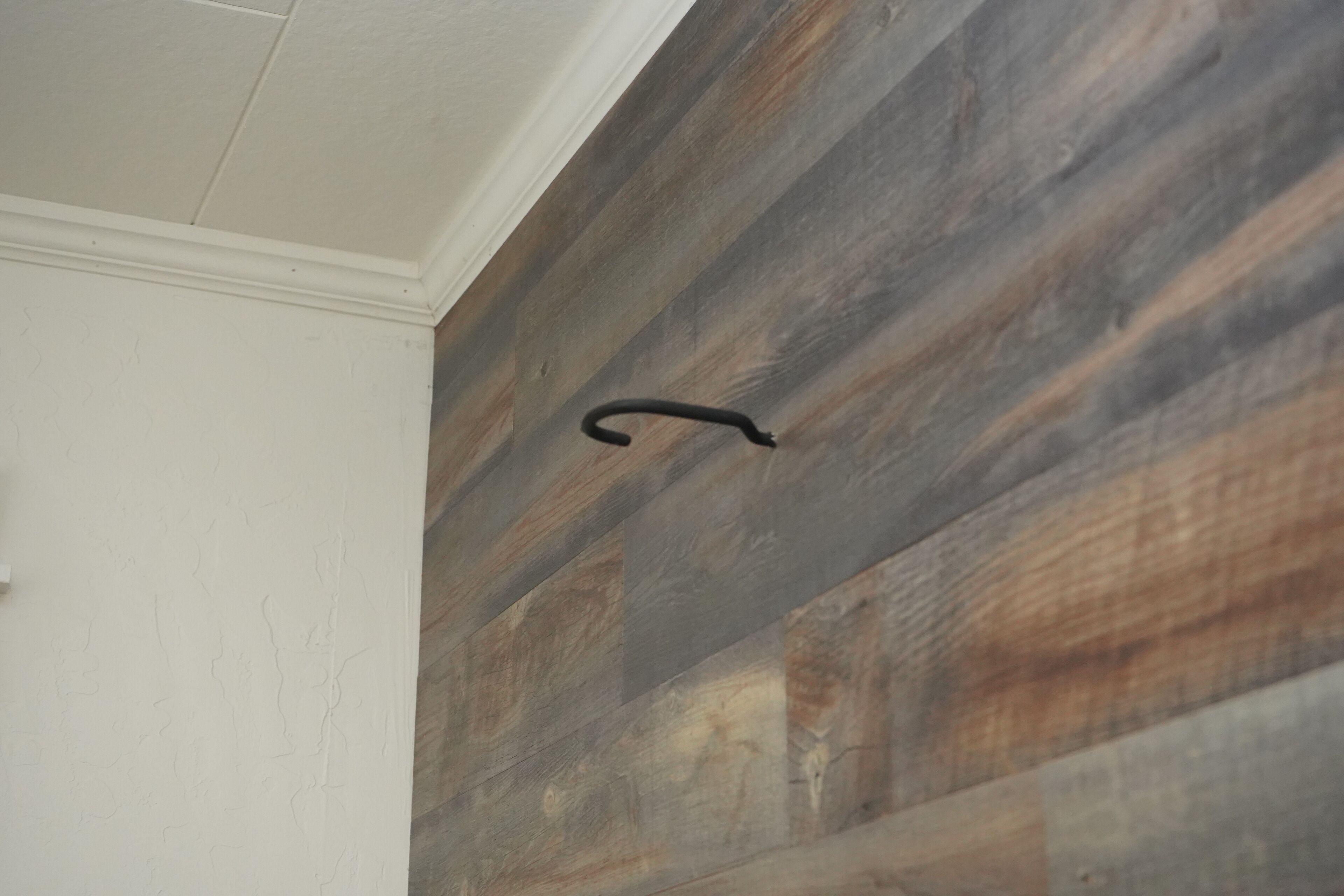 Una habitación con techo blanco y panel de pared de madera.