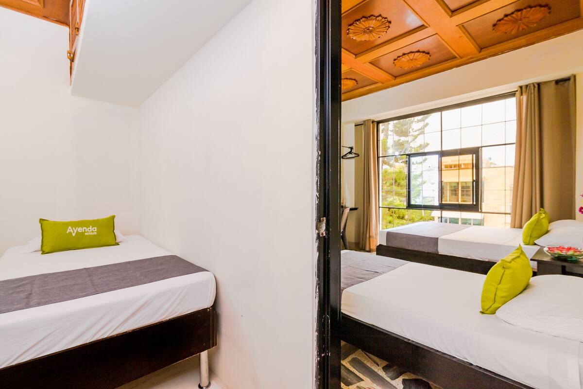 Une chambre d’hôtel avec deux lits, un plafond en bois et une vue sur l’extérieur.
