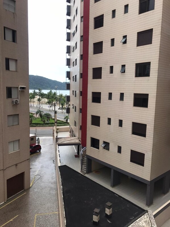 Um edifício residencial com vários andares e uma área de estacionamento na frente.