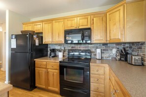 Lavavajillas, cafetera y tetera, utensilios de cocina y comedor 