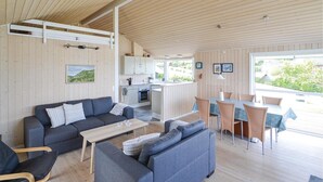 Een modern interieur met een bank, eettafel en keukenhoek.