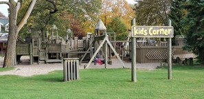 Kids can climb and play on the outdoor play structure featuring slides, steps, and platforms.