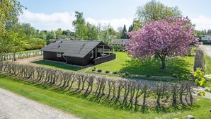 En rustik träladugård med ett sluttande tak och en täckt veranda.