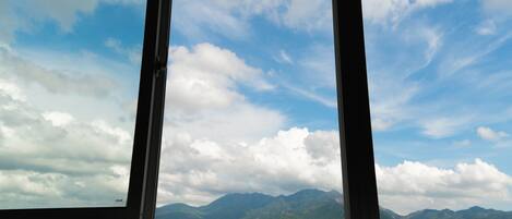 A view through a window with a mountain range in the background.