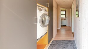 Ein Waschraum mit Waschmaschine, Spüle und Fenster.