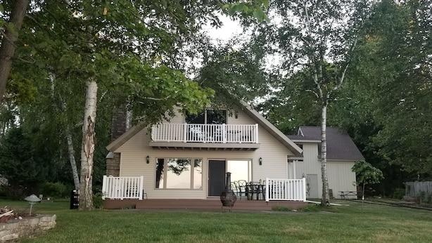 A two-story house with a balcony, a front door, and a small porch area. - Holiday Lodge on Green Bay (Sturgeon Bay)