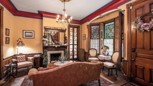A traditional living room with a fireplace, ornate furniture, and stained glass windows. - Gillis Grier Bed & Breakfast (Salisbury)