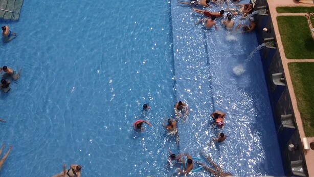 Una piscina interior amplia con varias pistas de natación y una zona poco profunda separada.