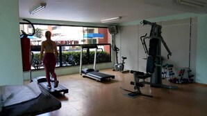 Un gimnasio con cinta de correr, bicicleta estática y máquinas de pesas.