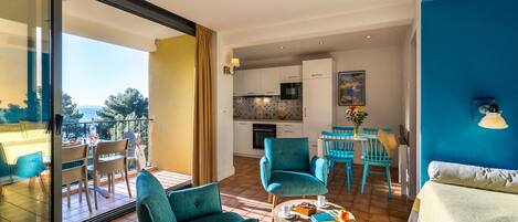 A modern apartment with a balcony, a kitchen, and a dining area.