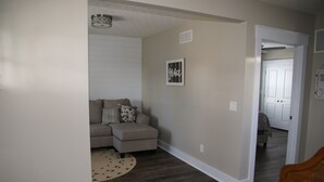 A living room with a sectional sofa, a round rug, and a framed word on the wall. - Gray's Landing- NEWLY Renovated / 1.8 miles to the ARK! (Williamstown)
