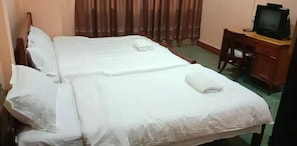 A double bed with white linens, a wooden headboard, and a television on a wooden desk. - Green Land Hotel (Vientiane)