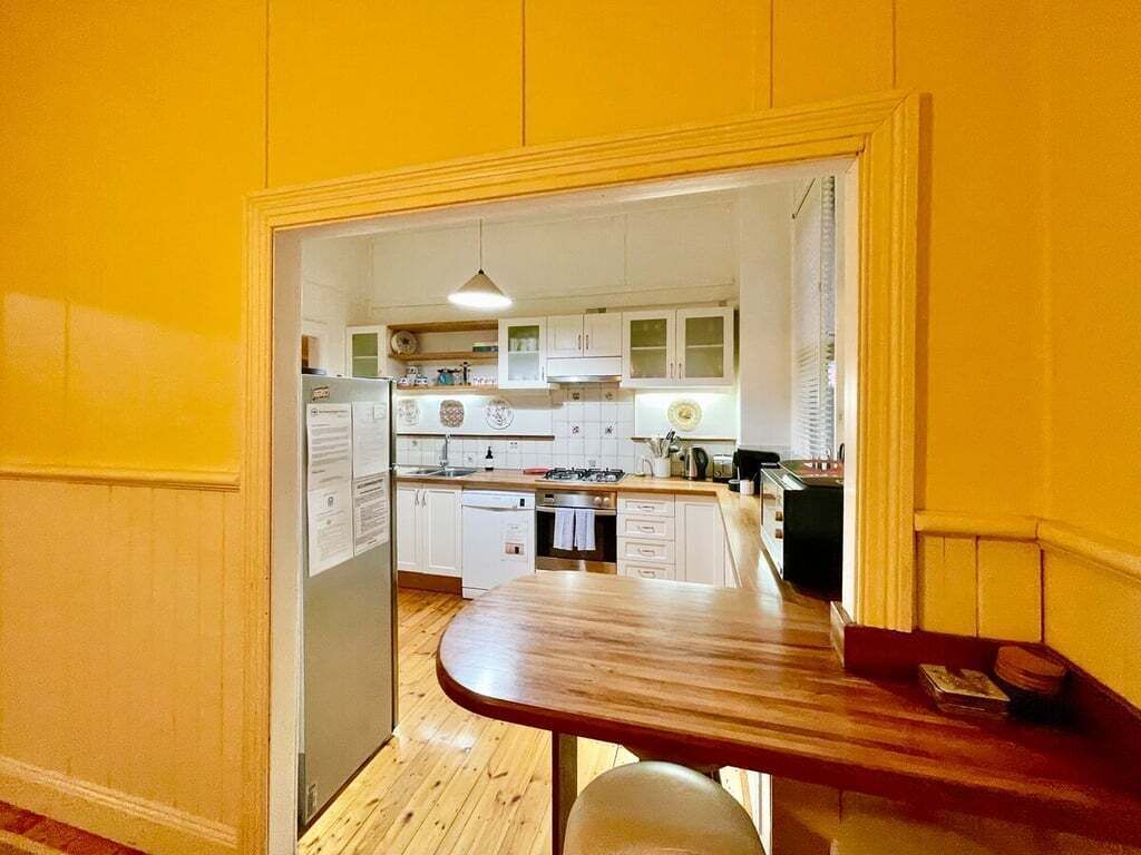 A kitchen with white cabinets, a wooden countertop, and a built-in dishwasher.