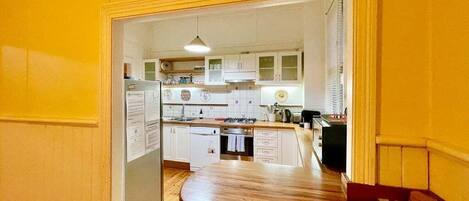 A kitchen with white cabinets, a wooden countertop, and a built-in dishwasher.