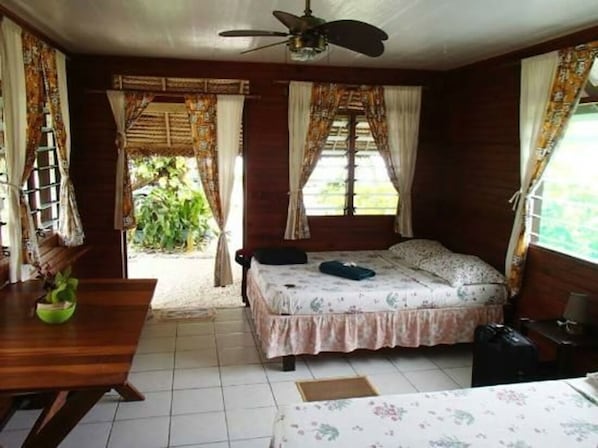 A room with a bed, a desk, and a ceiling fan. - Pension Chez Glorine (Rangiroa)