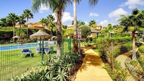 A pool area with a fenced pathway, palm trees, and a no swimming sign. - Mijas Costa Lovely Holiday Home for 6 (Mijas Costa)