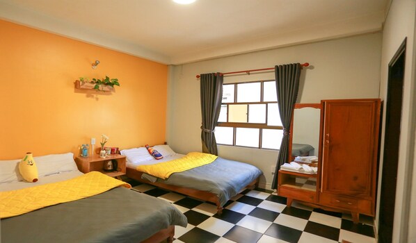 Una habitación de hotel con dos camas, un armario de madera, piso a cuadros y una ventana con cortinas.