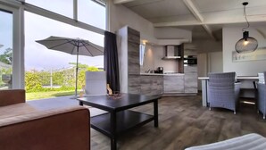 Uma cozinha moderna com forno embutido e área de refeições com mesa e cadeiras.