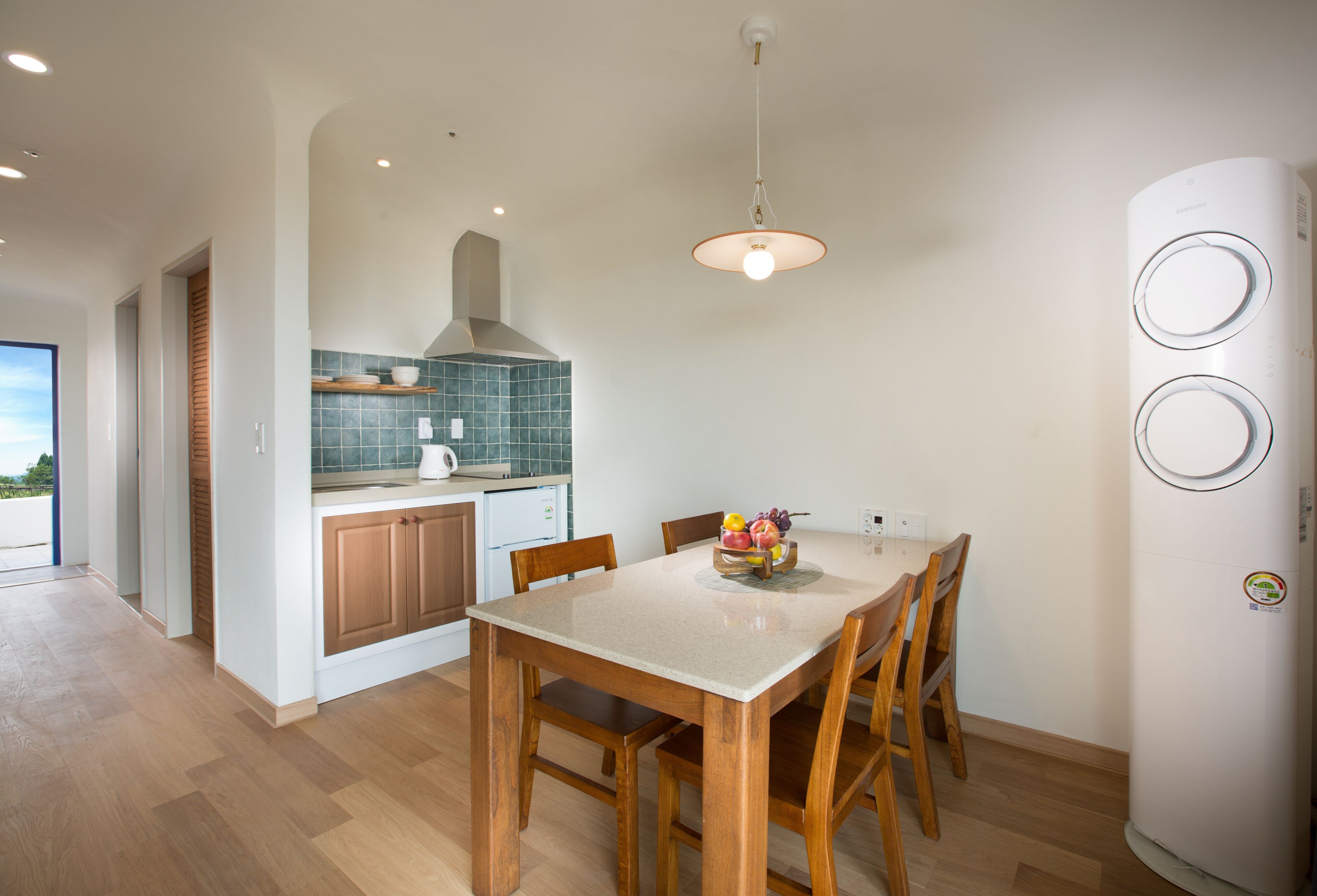 A modern kitchen with wooden cabinets, a tiled backsplash, and a dining table with chairs.