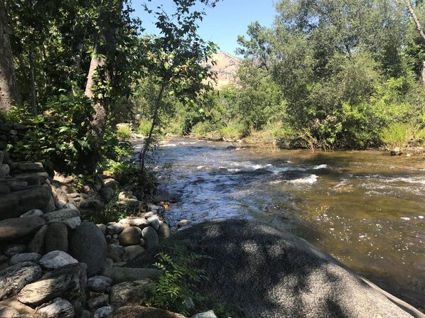 A river flowing through a rocky landscape with dense foliage and a stone structure on the left. -  "The Clouds River Villa " - Water front  paradise  7 miles from Sequoias Gate (Three Rivers)