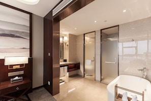 A modern bathroom with a large bathtub, a glass shower enclosure, and a vanity with a mirror. - Jinyi Jinglan Hotel (Jinhua)