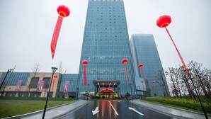 A modern building with a glass facade, red lanterns, and a clear sky. - Jinyi Jinglan Hotel (Jinhua)