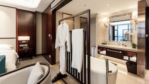 A modern hotel bathroom with a bathtub, a large mirror, and a robe rack. - Jinyi Jinglan Hotel (Jinhua)