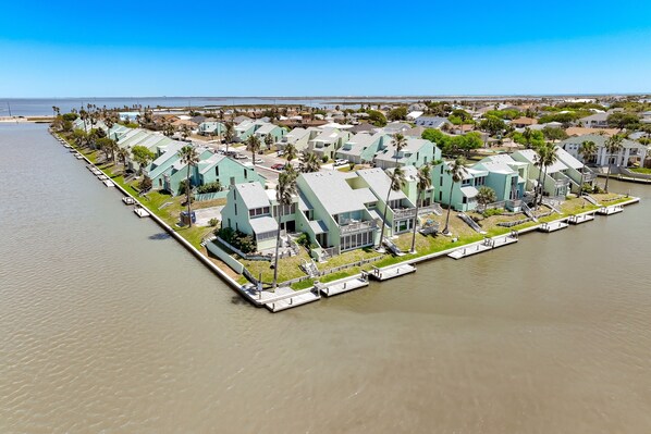 A waterfront property with multiple buildings, docks, and palm trees.