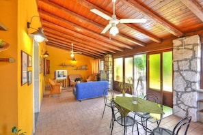 A cozy interior with a dining area, a sofa, and a television. - Villa in Sicily with Private Pool & Garden (Solarino)
