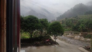 A rural landscape with a road, trees, and a stone wall. - Natural Lodge Homestay (Guilin)