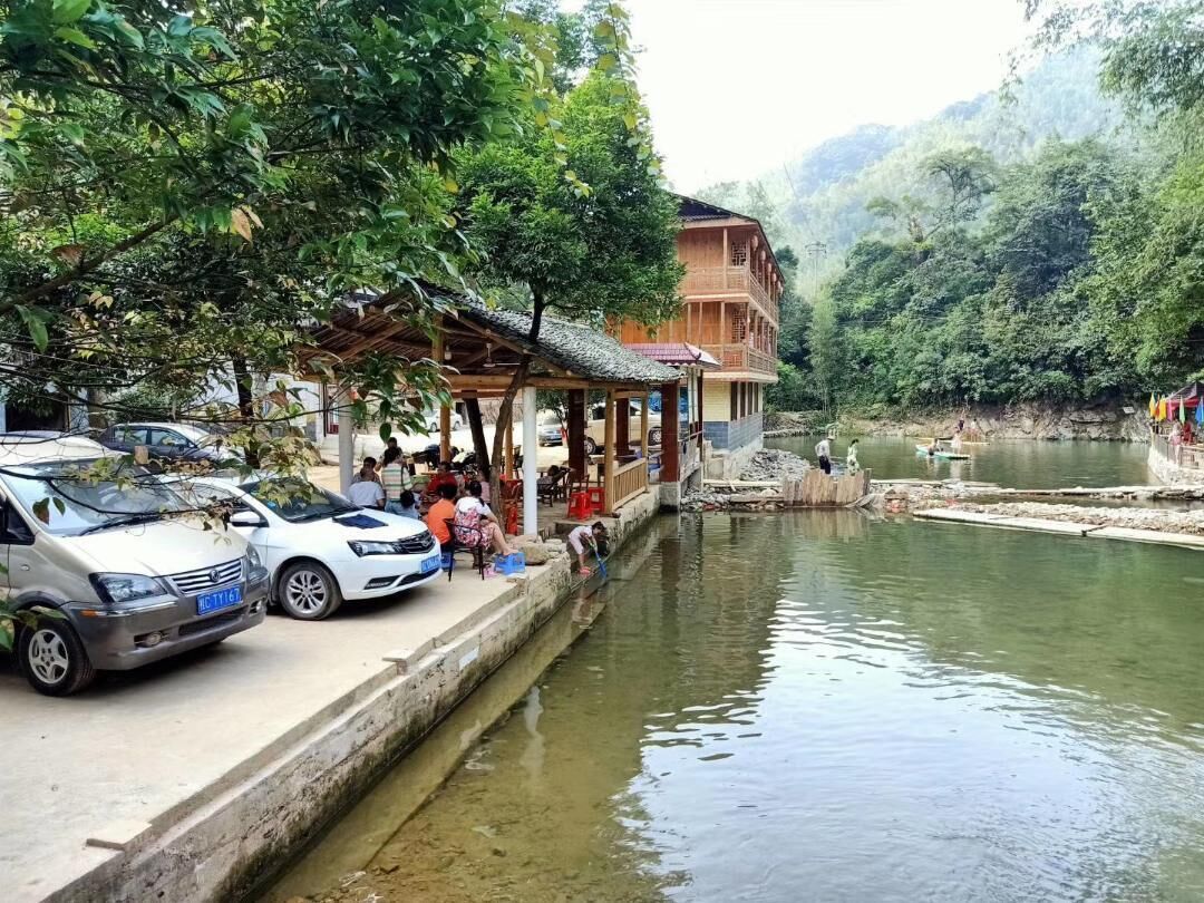 A riverside building with a covered porch, a dock, and a calm river.