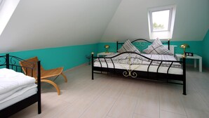 A bedroom with a bed, a chair, a window, and a nightstand. - Appartementhaus am Kiessee, Westerholt (Westerholt)