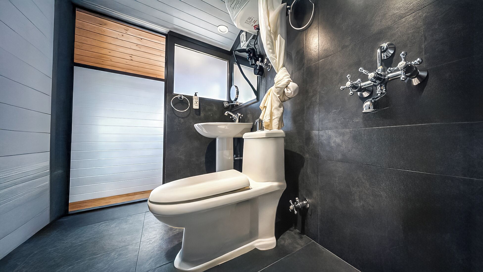 Een moderne badkamer met een wit toilet, een wastafel en een douche met gordijn.