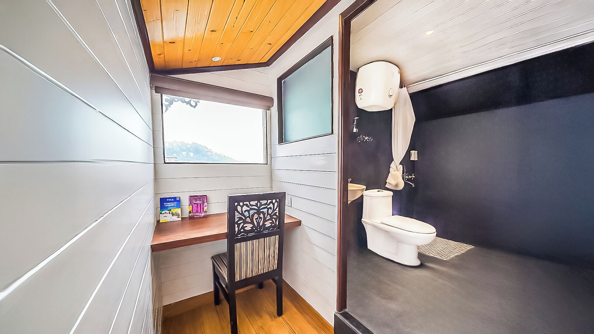 A compact bathroom with a toilet, a shower area, and a window with a view.