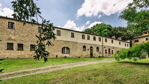 A stone building with multiple windows and a central courtyard.
