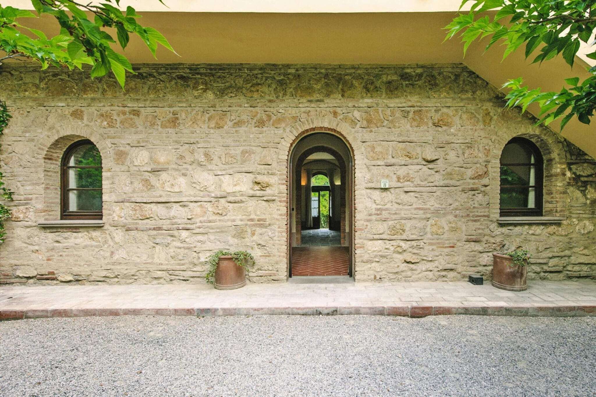 Un edificio de piedra con tres ventanas de arco y una puerta central.