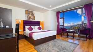 A modern hotel room with a large bed, a desk, and a view of the city. - Sumitel Hotel 500 meters from Mall Road (Darjeeling)