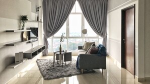 A modern living room with a sofa, a coffee table, and a ceiling fan. - Boulevard Service Apartment KL by Airhost (Kuala Lumpur)