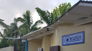 Ein Gebäude mit einem Schild, das „Oasis“ zeigt, und einem abgestellten Roller.