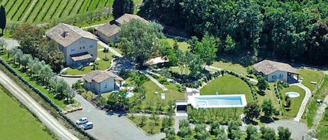 A residential area with multiple houses, a swimming pool, and a road.