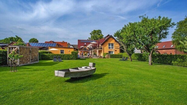 Ein Wohngebiet mit Häusern, einem Boot im Garten und blauem Himmel.