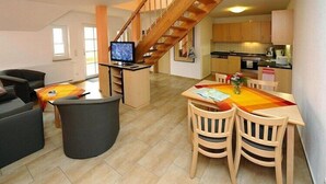 Eine moderne Wohnung mit Essbereich, Küche und Wohnzimmer.