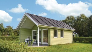 A small, single-story house with a sloped roof, a covered porch, and a grassy yard. - 1 bedroom cozy home in Grindsted (Grindsted)