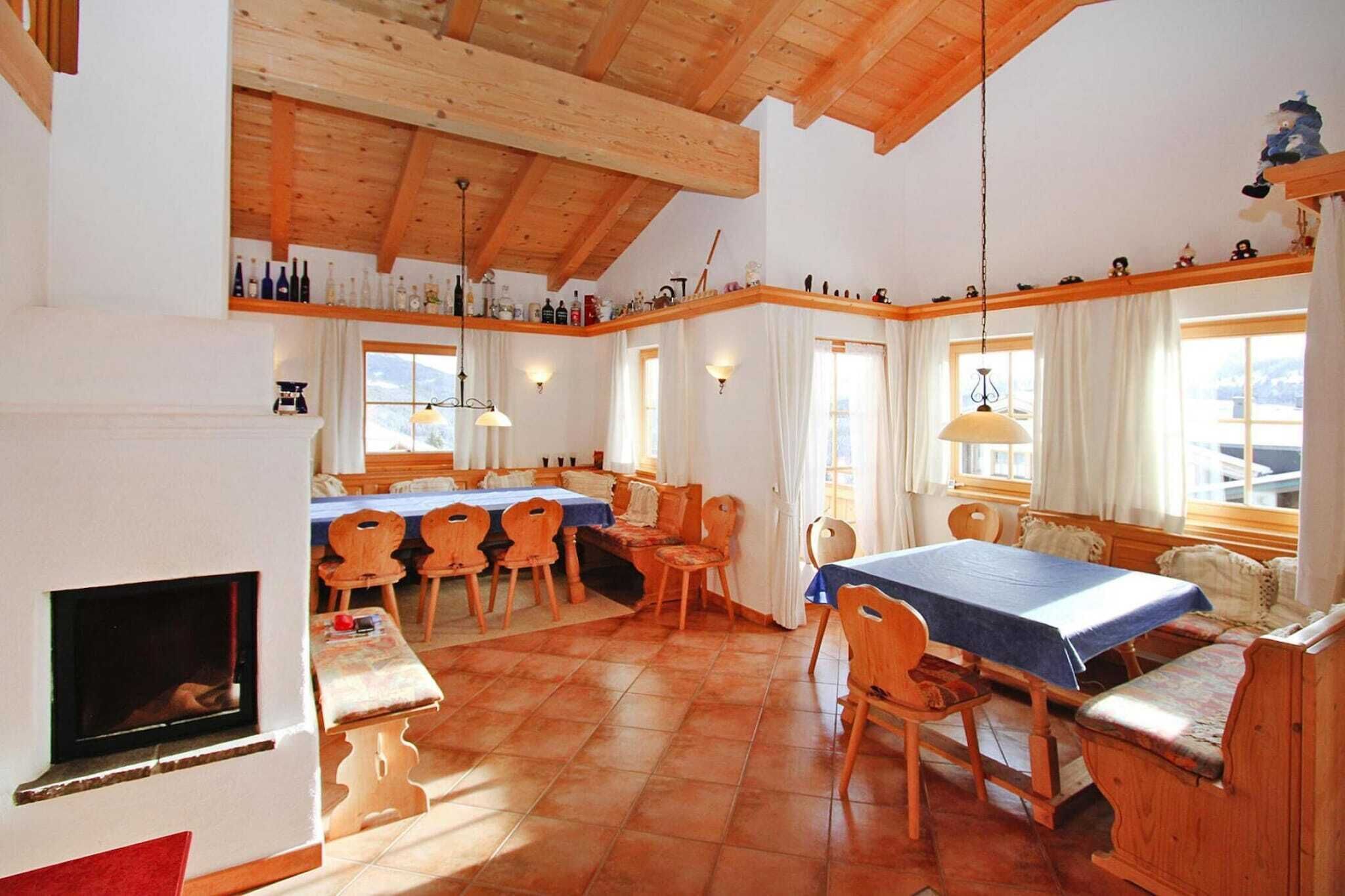Ein gemütliches Zimmer mit Kamin, Holzmöbeln und einem Essbereich mit Tisch und Stühlen.