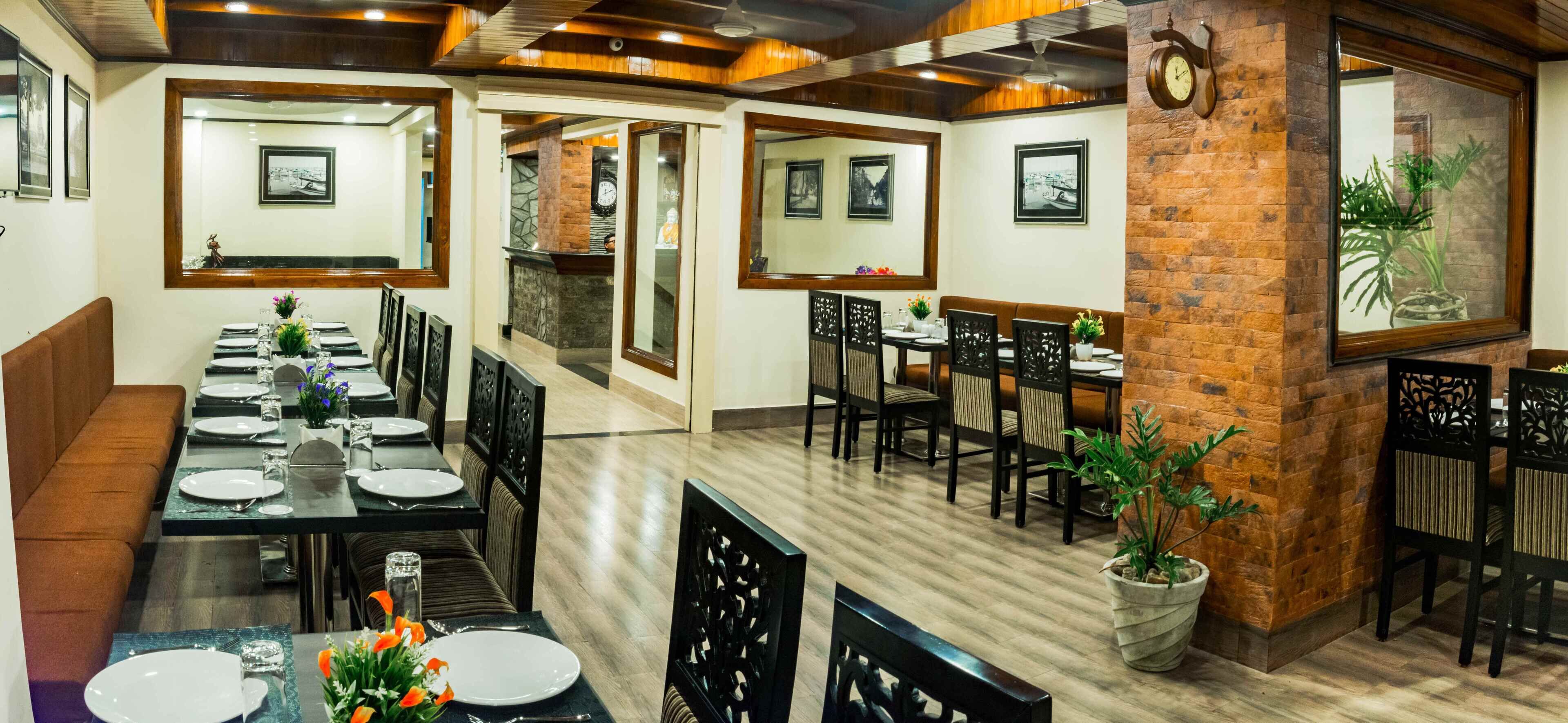 Un restaurante con una larga mesa de comedor, múltiples sillas y una pared de ladrillo decorativa.