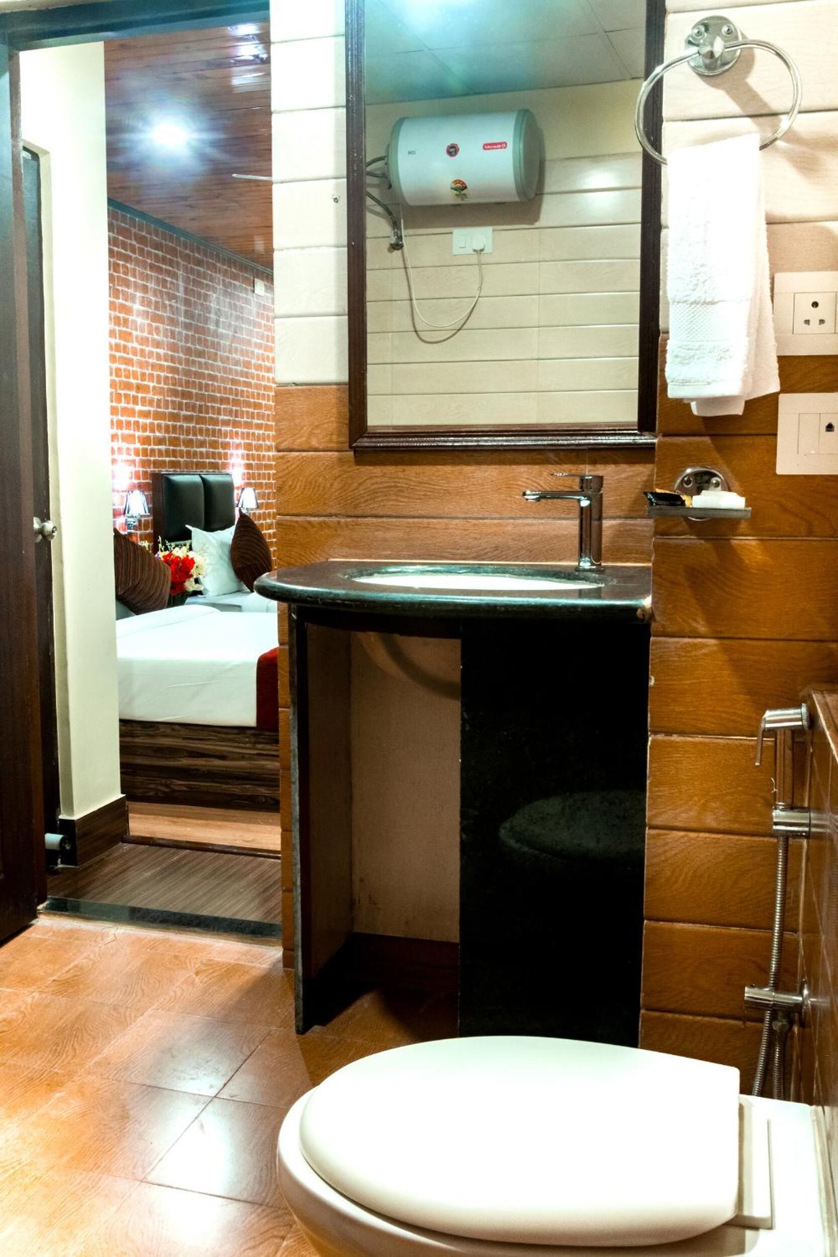 A bathroom with a sink, toilet, and a mirror.