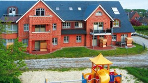 Un immeuble à plusieurs étages, construit en briques, avec une façade rouge et un toit bleu.