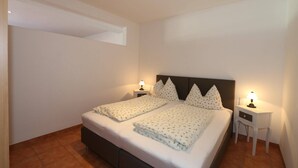 A bedroom with a bed, two bedside tables, and a nightstand. - Apartment in Zugspitz Arena near Highline 179 (Bichlbach)