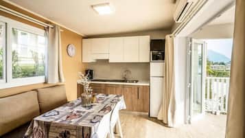 Une cuisine compacte avec un coin repas, un canapé et une vue sur l’extérieur.